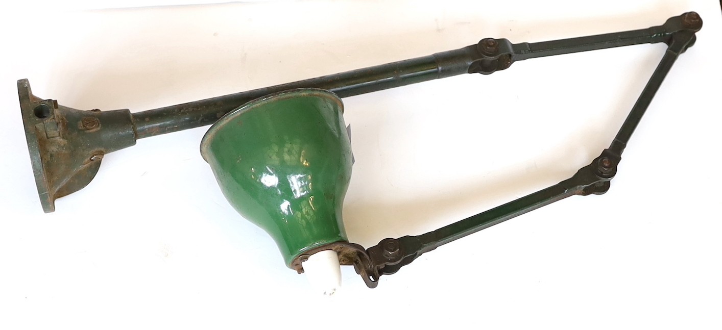 A 1920s painted and enamelled metal adjustable machine bench lamp, height 70cm